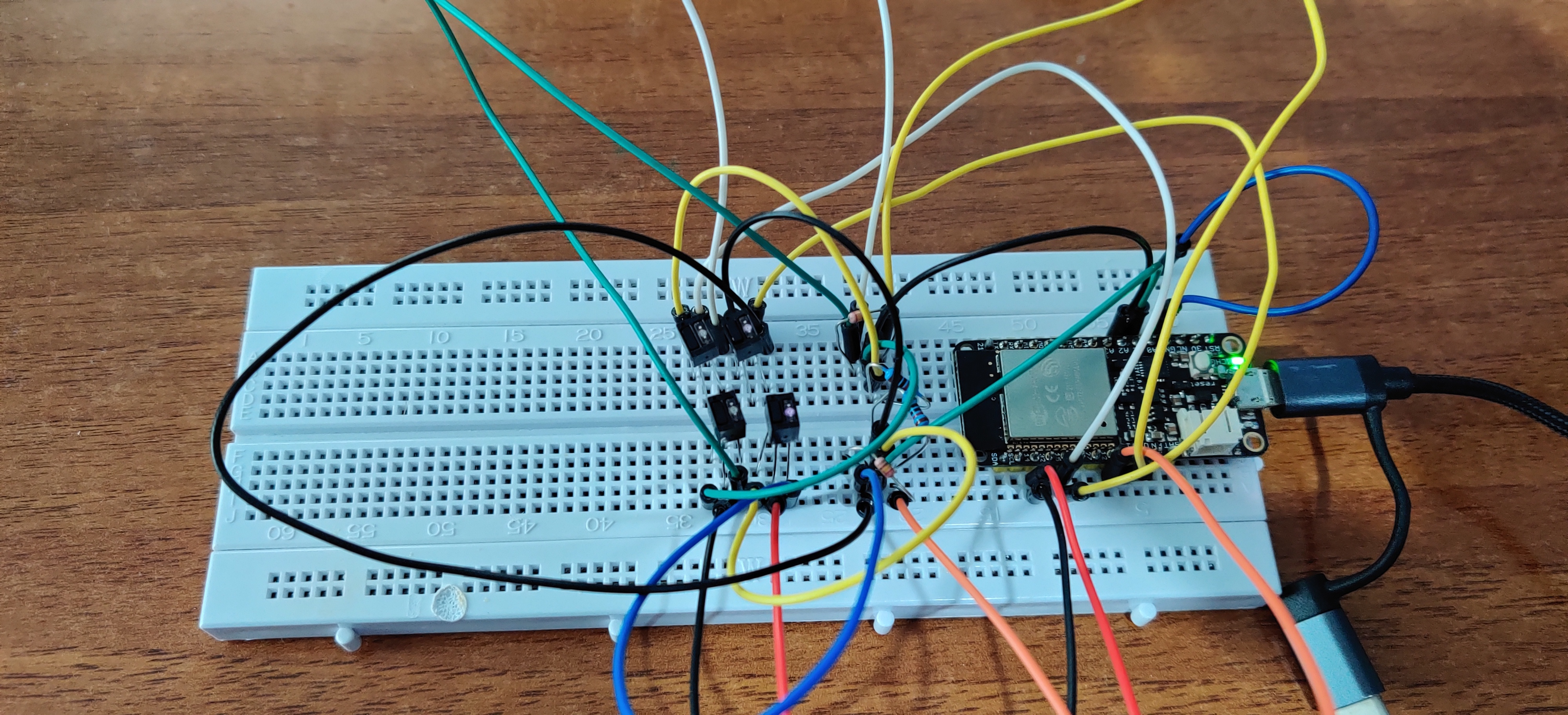 breadboard con un ESP32, 4 sensori QRD1114, quattro
resistenze, e un po' di fili. Un LED fa una debole luce rosa,
gli altri sono spenti