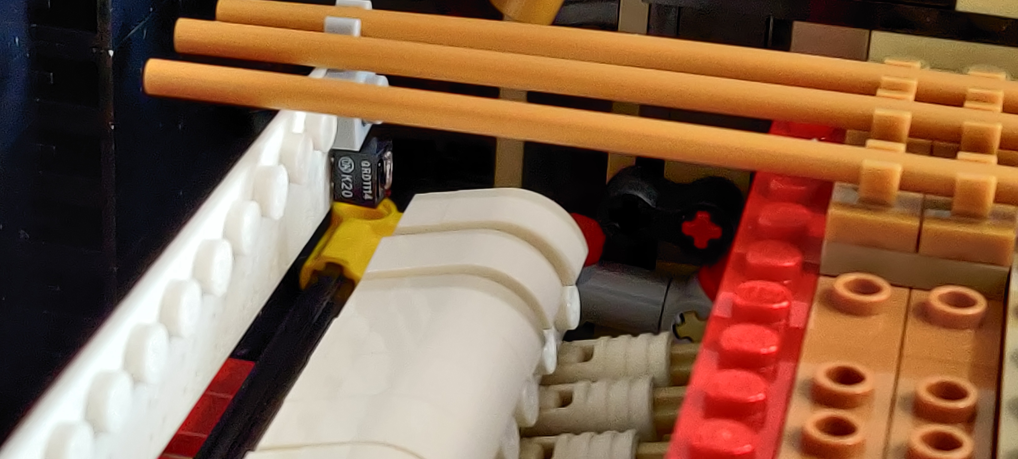 un sensore QRD1114 inserito nel supporto stampato, appeso a
una delle "corde" con una manina Lego; il sensore è appena
sopra e dietro l'ultimo martelletto a destra; il martelletto
è a riposo